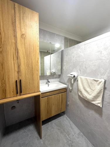 a bathroom with a sink and a mirror at ÇAMLIK APART in Ayvalık