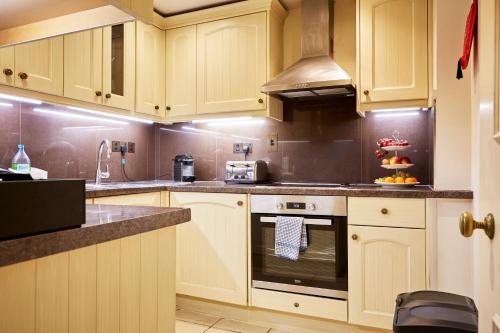 a kitchen with wooden cabinets and a stove top oven at 9 Hertford Street Mayfair in London