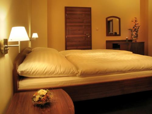 a bedroom with a bed with a table and a lamp at Parkhotel Centrum in Spišská Nová Ves