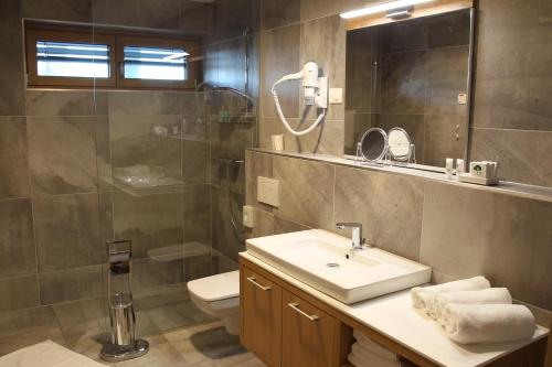 a bathroom with a sink and a shower and a toilet at Pan Prenočišča in Ptuj