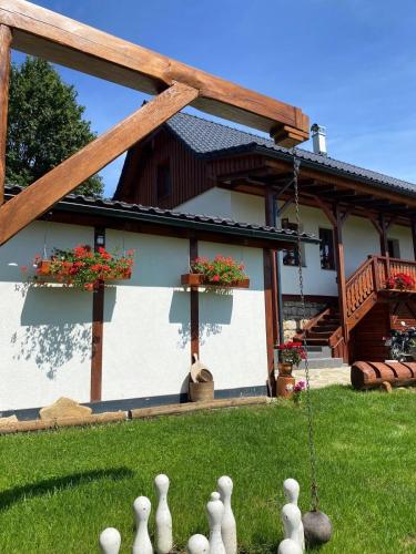 a house with a garden with a group of white statues at Chalupa Na Bačáku in Frýdek-Místek