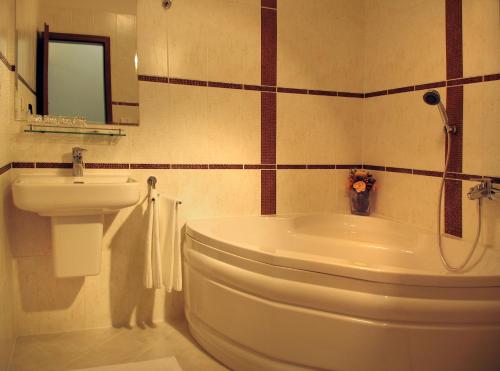 a bathroom with a white tub and a sink at Parkhotel Centrum in Spišská Nová Ves