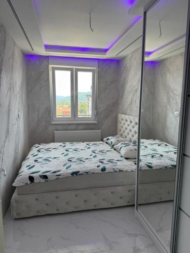 a small bedroom with a bed and a window at NelaLux 2 in Bratunac