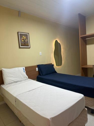 a bedroom with two beds and a couch at Hotel Amado in Aracaju