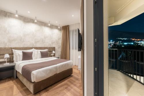 a bedroom with a king sized bed and a balcony at Hotel Bulevar Mostar in Mostar