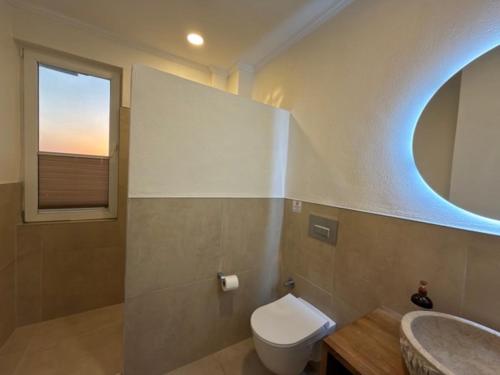 a bathroom with a toilet and a sink and a window at Villa Zalin in Ovacik
