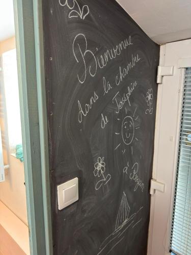 a chalkboard with writing on a door in a room at La chambre de Joséphine in Royan