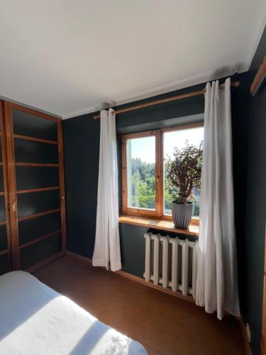 a bedroom with a window and a radiator at Aluksne city nest in Alūksne