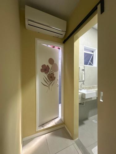 a bathroom with a painting of flowers on the wall at Hotel Amado in Aracaju