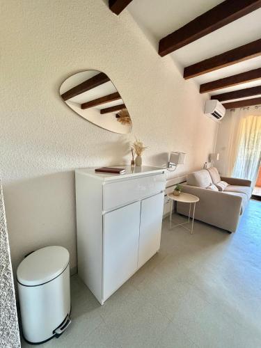 a white kitchen with a couch and a table at Stella-Bianca in Sagone
