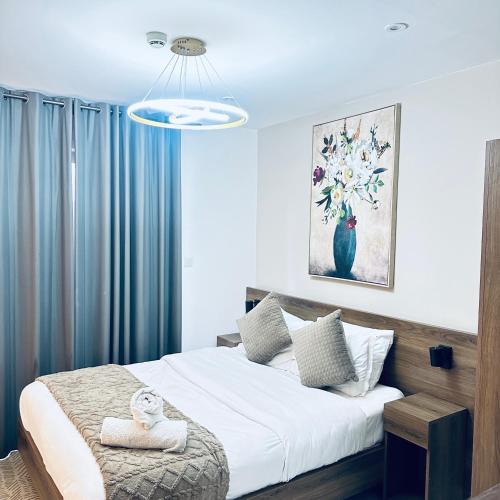 a bedroom with a large bed with blue curtains at Loxwood by Tripview Apartments in Accra