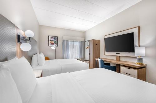 a hotel room with two beds and a flat screen tv at Best Western Inn Florence in Florence