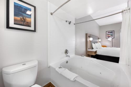 a white bathroom with a tub and a bed at Best Western Inn Florence in Florence