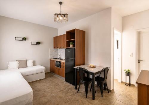 a small room with a small table and a kitchen at Aigaion Aetherium Apartments in Livadakia