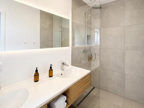 a white bathroom with a sink and a shower at Baltic Center Bungalows in Sarbinowo