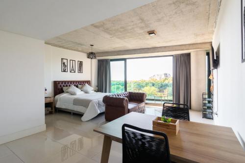 a bedroom with a bed and a table and chairs at Nova Stays - Estudio con balcón al Jardín Botánico de Palermo in Buenos Aires