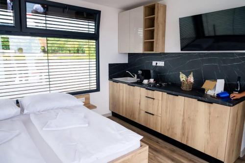 a bedroom with a large white bed and a sink at Houseboat Glamour & wellness in Kaluža