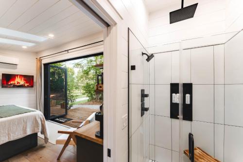 a room with a glass door leading to a bedroom at Glamping cottage with glass front and hot tub! in Guntersville