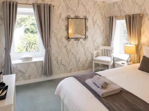 a bedroom with a bed and a chair and a window at C'est la vie in Saint-Malo des 3 Fontaines