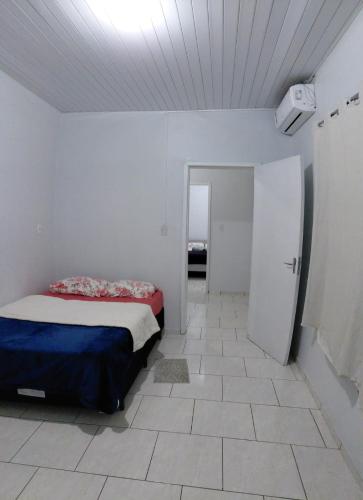 a bedroom with a bed in a white room at Pousada familiar 07 in Rio do Sul