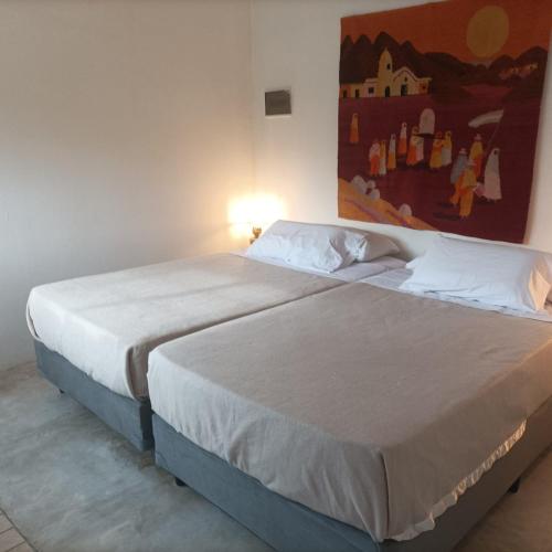 a bedroom with two beds and a painting on the wall at La casita anaranjá in Villa Allende