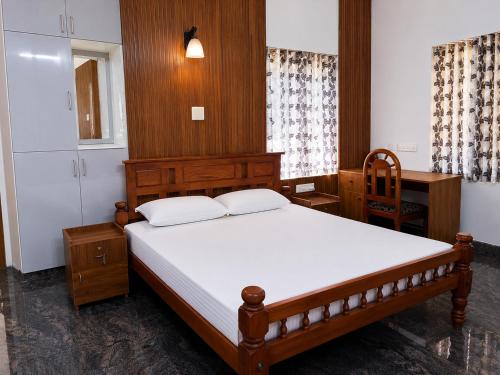 a bedroom with a wooden bed and a desk at Bamivigas Retreat in Kattappana