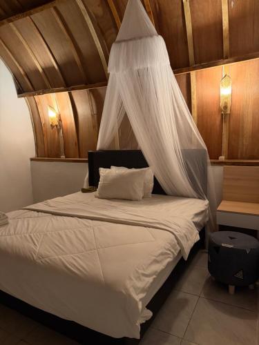 a bedroom with a bed with a mosquito net at Ekas Rising Coffee And Cottages in Ekas