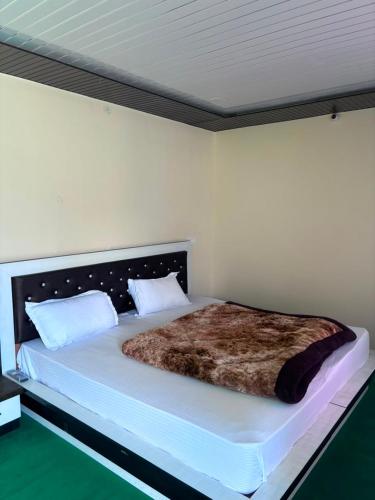 a bedroom with a large bed with a brown blanket at Alpine Homestay in Joshīmath