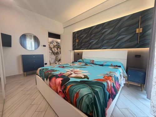 a bedroom with a large bed with a colorful blanket at Lo Snodo Apartments cucina e parcheggio in Pomigliano dʼArco