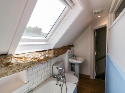 a skylight in a bathroom with a toilet and a sink at Netherend Barn in Colwall