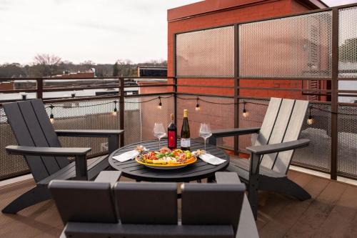 Ein Tisch und Stühle auf einem Balkon mit einer Schüssel Essen in der Unterkunft Three Trails Downtown Elkin in Elkin
