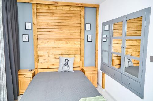 a bedroom with a bed and a wooden wall at Вила Якимови in Ribarica