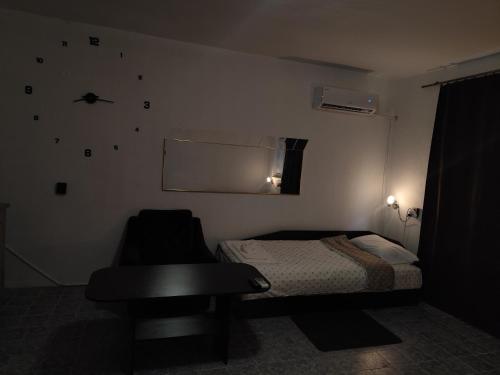 a bedroom with a bed and a table and a chair at Стая за гости При Валко in Belogradchik