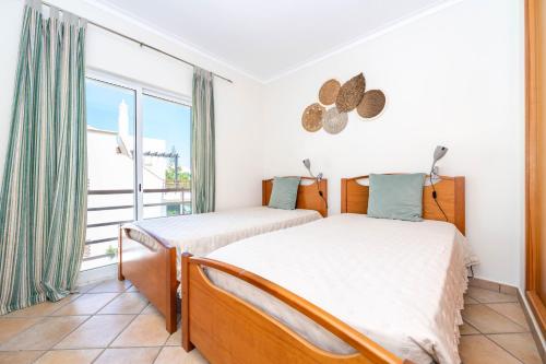 two beds in a bedroom with a balcony at Quinta da Gomeira by Algartur in Cabanas de Tavira