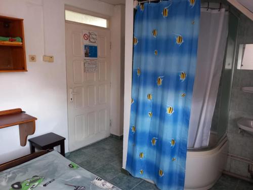 a bathroom with a shower with a shower curtain with fish on it at Hangya panzió in Târgu Secuiesc