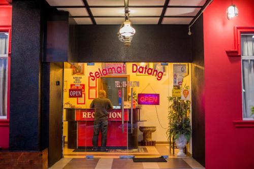 a man standing in the doorway of a store at Menara One Hotel in Kota Bharu