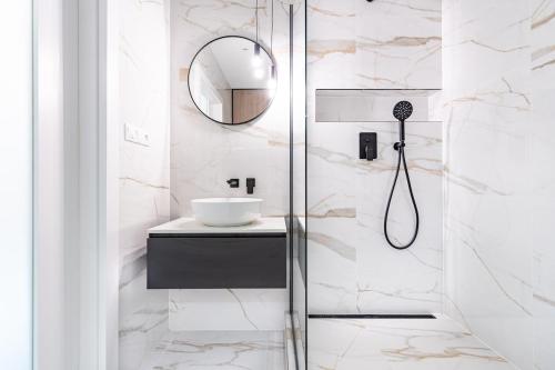 a bathroom with a shower with a sink and a mirror at MCK Apartments in Košice