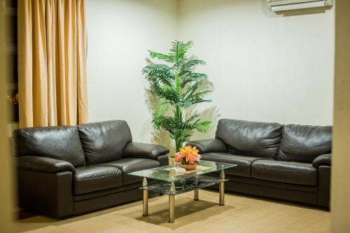 a living room with leather couches and a coffee table at Menara One Hotel in Kota Bharu