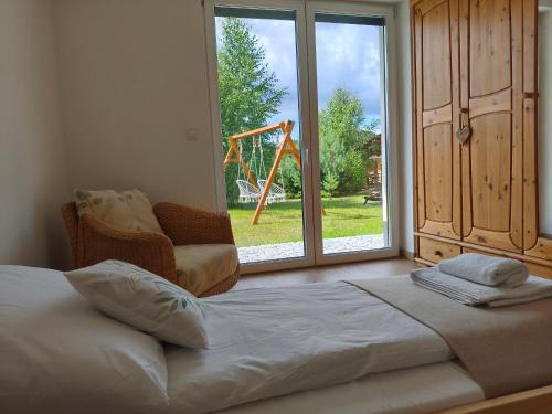 a large bed in a room with a large window at Domek na Polanie Rekowo in Pollnow
