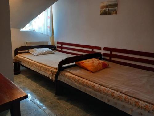 two twin beds in a room with a window at Hangya panzió in Târgu Secuiesc