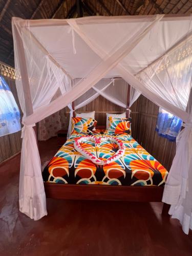 a bed with a canopy in a room at Lokobe Djema Forest Lodge in Nosy Be