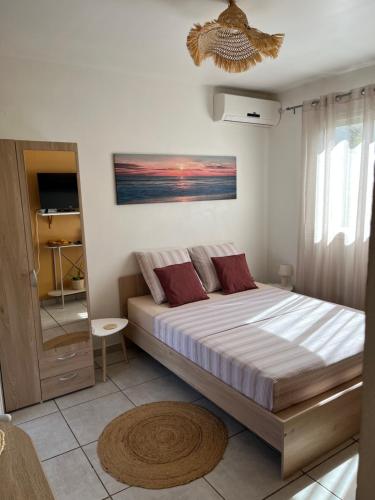 a bedroom with a large bed with red pillows at lagon studio ermitage in Saint-Paul