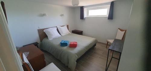 a small bedroom with a bed with two boxes on it at Rosabelle in Beaulieu-sur-Dordogne