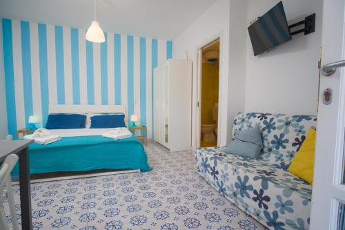 a blue and white bedroom with a bed and a couch at Labottega home in Lipari