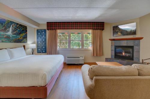a bedroom with a large bed and a fireplace at Bearskin Lodge on the River in Gatlinburg