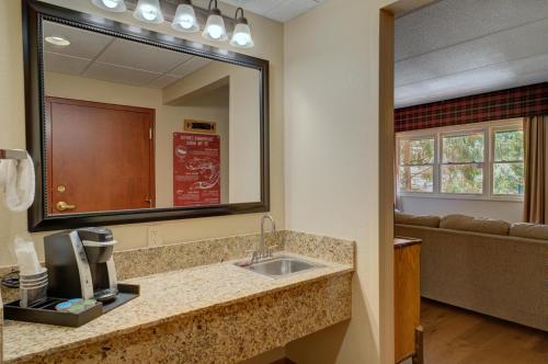 a bathroom with a sink and a mirror and a couch at Bearskin Lodge on the River in Gatlinburg
