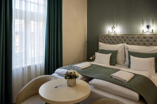 a hotel room with a bed with a table and a window at Nádor Rezidencia in Győr