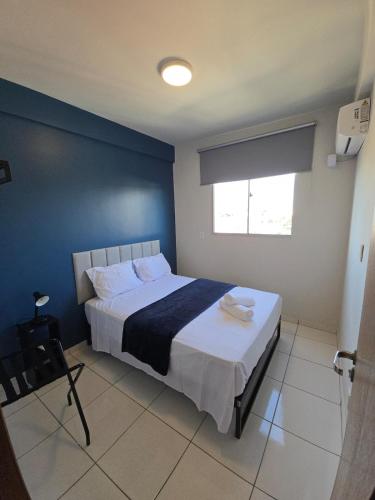 a bedroom with a large bed with a blue wall at Apto com 2 quartos e A/C no Centro in Montes Claros