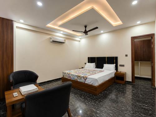 a bedroom with a bed and a desk and a ceiling at Hotel Del Luna in Greater Noida