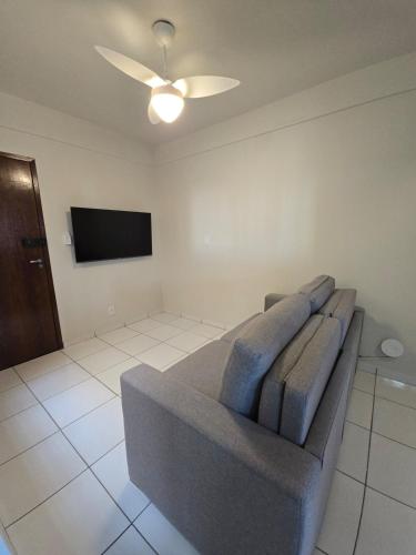 a living room with a couch and a flat screen tv at Apto com 2 quartos e A/C no Centro in Montes Claros